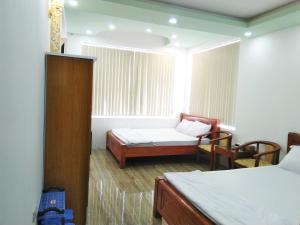 Habitación pequeña con 2 camas y ventana en Khách sạn Gia Nghiêm en Ấp Trà Kha