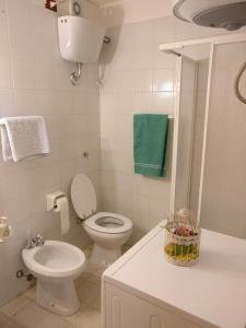 een witte badkamer met een toilet en een wastafel bij CASA VACANZE ARBORIAMAR SORSO SARDEGNa in Marina di Sorso