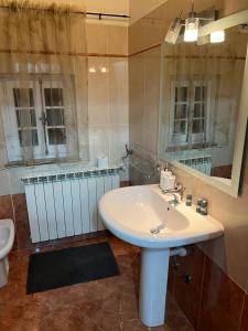 y baño con lavabo blanco y espejo. en Camera matrimoniale con terrazza panoramica, en Serina