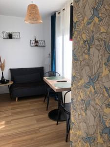 salon ze stołem i kanapą w obiekcie Cosyade Parking privé gratuit w mieście Bourbourg