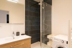 a bathroom with a shower and a sink and a washing machine at DIFY Cordeliers - Centre Ville in Lyon