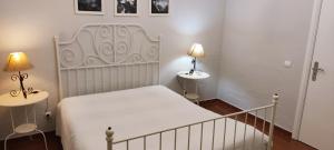 a bedroom with a white bed and two lamps at Quinta da Abrunheira in Vimieiro