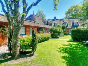 a house with a tree in the yard at Hus op de Dün Storchennest in Sankt Peter-Ording