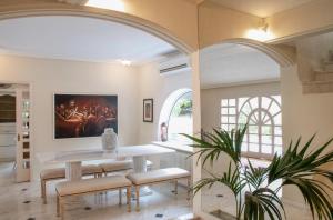 una sala da pranzo con arco, tavolo e sedie di Eden Garden 3BR villa with Pool by JJ Hospitality a Oropos