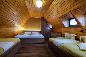een kamer met 2 bedden in een houten hut bij Chata Pri potoku in Stará Lesná
