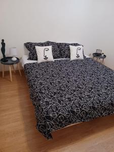 een bed met een zwart-witte deken en 2 kussens bij Lovely Apartment Piantade in Poreč