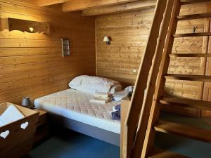 mały pokój z łóżkiem w drewnianym domku w obiekcie Chalet le Grand Bec w mieście Champagny-en-Vanoise
