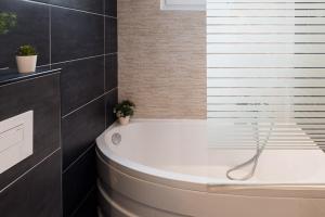 a bathroom with a bath tub with two potted plants at Charming one-of-a-kind apartment. in Saint-Ouen