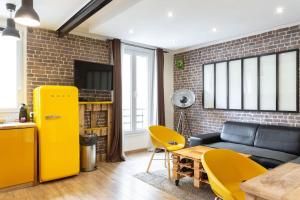Una sala de estar con un sofá y un refrigerador amarillo. en Charming one-of-a-kind apartment., en Saint-Ouen