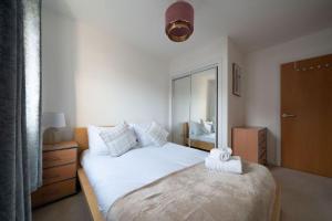 a bedroom with a large white bed and a mirror at Hope House - 2 bedroom flat in Aberdeen