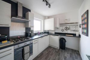 a kitchen with white cabinets and a stove top oven at Hope House - 2 bedroom flat in Aberdeen