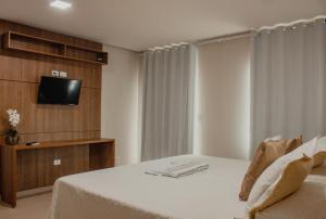 a bedroom with a bed with a tv on a wall at Pousada Chayenne in Piranhas