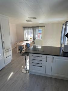 uma cozinha com armários brancos e uma mesa e cadeiras em Lärkan 21 Tvisegatan 24 em Borlänge