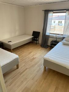 a room with two beds and a desk and a window at Lärkan 21 Tvisegatan 24 in Borlänge