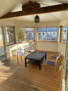 eine abgeschirmte Veranda mit einem Tisch und Stühlen in der Unterkunft Lärkan 21 Tvisegatan 24 in Borlänge