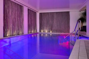 una piscina con iluminación púrpura en una casa en La Villa Haussmann, en París