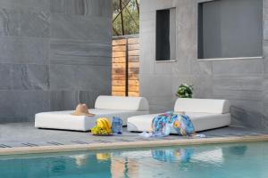 - deux lits à côté d'une piscine dans l'établissement Harmony Residences Pool villas, à Ialyssos