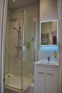 a bathroom with a glass shower and a sink at Blakeney House in Blakeney