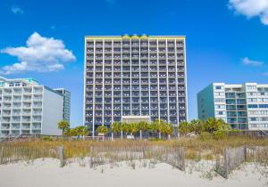 a tall building on the beach with buildings at Monterey Bay Suites in Myrtle Beach