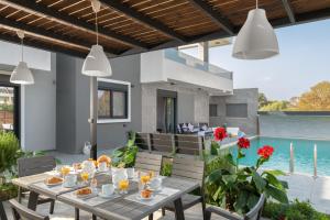 イアリソスにあるHarmony Residences Pool villasの屋外ダイニングエリア(テーブル、椅子付)、プールが備わります。