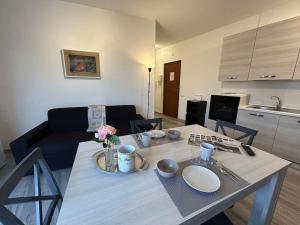 een woonkamer met een tafel met borden en bloemen erop bij Casa Olympia in Peschiera del Garda