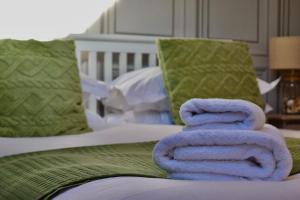 a pile of towels sitting on top of a bed at Blakeney House in Blakeney