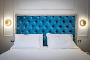 a bed with a blue headboard and two white pillows at Residenza Giotto in Florence