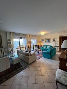 uma grande sala de estar com sofás e cadeiras azuis em Classy Penthouse em Imola
