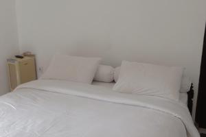 a white bed with white sheets and pillows at Villa Adhi Rajasa in Penebel