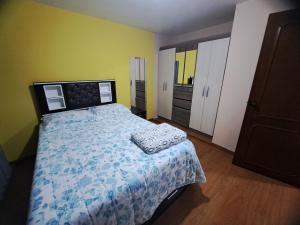1 dormitorio con cama y pared amarilla en Departamento amoblado en Arequipa, Cerro Colorado, Urbanización La Merced de Challapampa en Challapampa