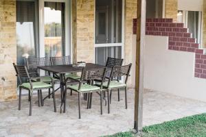 a wooden table and chairs on a patio at Family Villas in Vourvourou