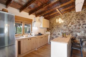 a kitchen with wooden ceilings and a stone wall at Laurelin in Candelaria