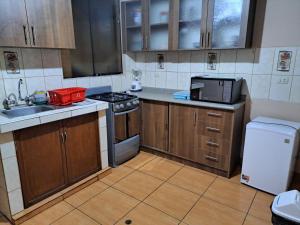 a kitchen with a sink and a stove top oven at Departamento amoblado en Arequipa, Cerro Colorado, Urbanización La Merced de Challapampa in Challapampa