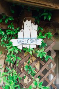 um sinal que diz bem-vindo é anexado a uma planta em Family Villas em Vourvourou
