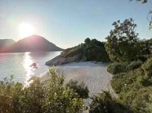 a beach with the sun shining on the water at Asteri Apartments Mytikas 2-Bedroom Seaview Courtyard in Mitika