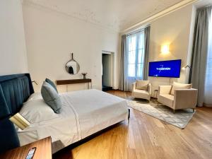 um quarto de hotel com uma cama e uma televisão de ecrã plano em The Seven Suites em Gênova