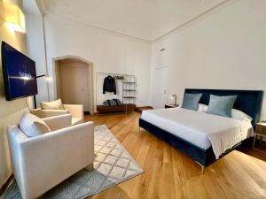 a large bedroom with a bed and a couch at The Seven Suites in Genova
