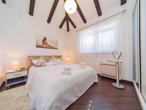 um quarto branco com uma cama grande e uma janela em 4B apartments Dubrovnik em Dubrovnik