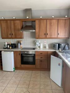 a kitchen with wooden cabinets and white appliances at Serenity Cottage in Lisnaskea