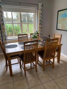 a dining room with a table and chairs and a window at Serenity Cottage in Lisnaskea