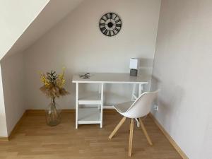 ノルトハイムにあるFerienwohnung Seeblickの白いデスク(椅子付)、壁掛け時計