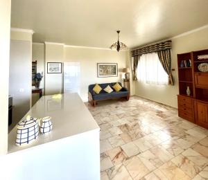 een keuken en een woonkamer met een bank en een tafel bij Cosy Sea View Apartment in Costa da Caparica