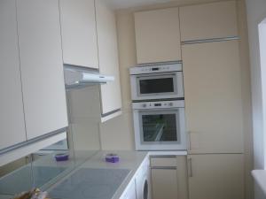 a white kitchen with a stove and a microwave at Coeur de Cannes in Cannes