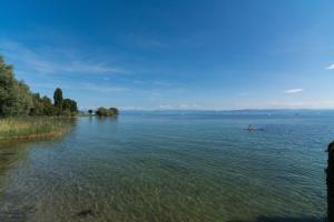 a person in a boat on a large body of water at Ferienwohnung Ankerplatz 1 in Immenstaad am Bodensee