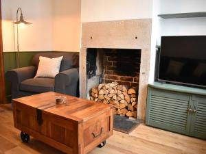 uma sala de estar com lareira e televisão em Church View Cottage em Ashbourne