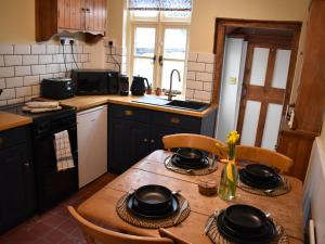 - une cuisine avec une table en bois avec des casseroles et des poêles dans l'établissement Church View Cottage, à Ashbourne