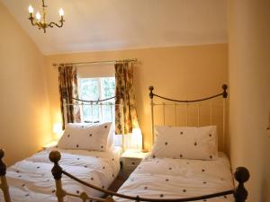 um quarto com 2 camas e uma janela em Church View Cottage em Ashbourne
