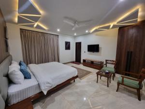 a bedroom with a bed and a living room with a tv at Grand Hotel Quetta in Quetta