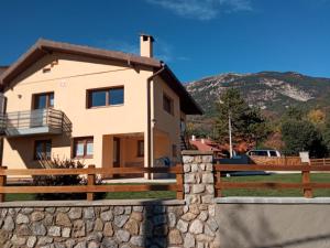 una casa con una pared de piedra y una valla en Allotjament Cal Bru, en Sant Llorenç de Morunys