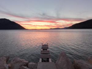 a dock in the middle of a lake with a sunset at Asteri Apartments Mytikas 2-Bedroom Seaview Courtyard in Mitika